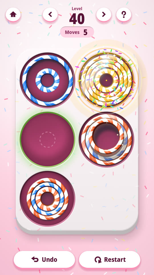 A Ring by ring level in Ringol: several stacks of nested rings in mixed colours on a tray